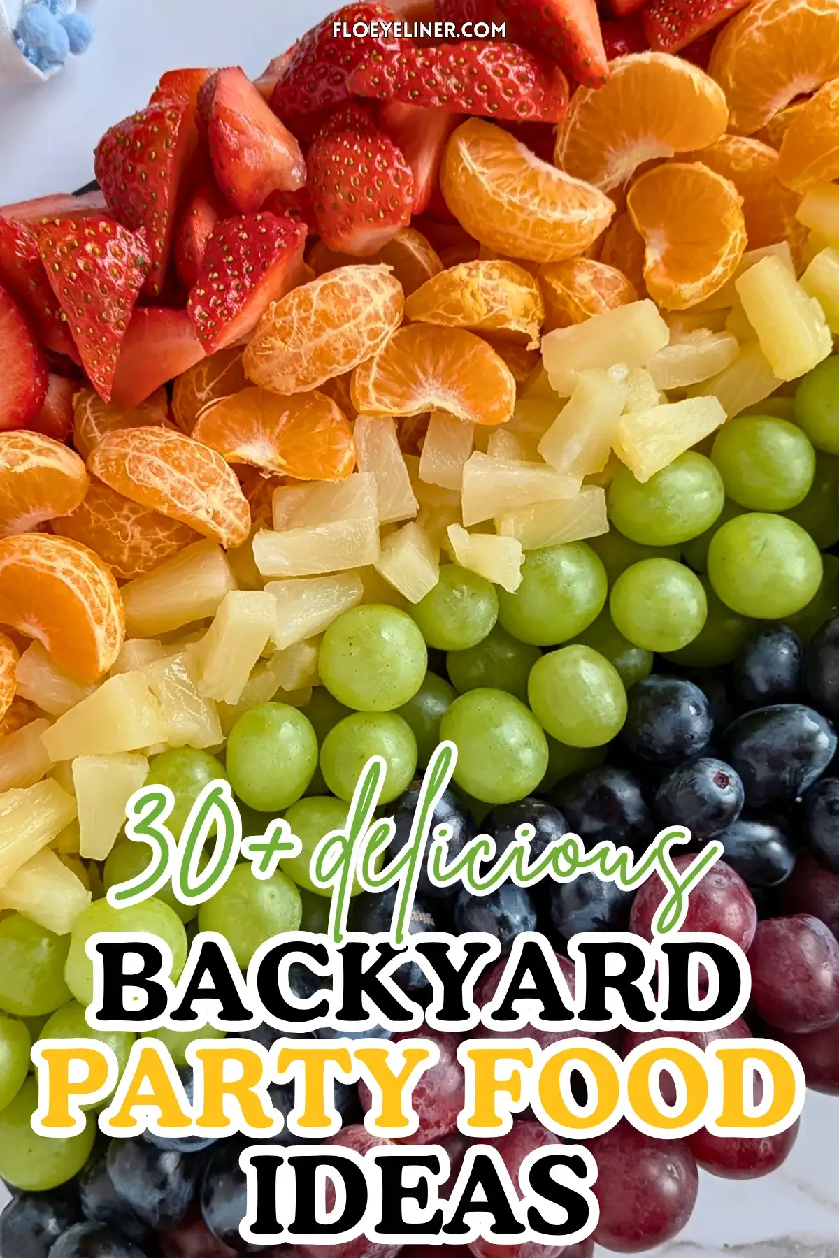 Rainbow Fruit Tray - colorful fruit platter in rainbow colors made with fruits and berries like strawberries, mandarin segments, canned pineapple pieces, green grapes, blue grapes, and dark red grapes.
