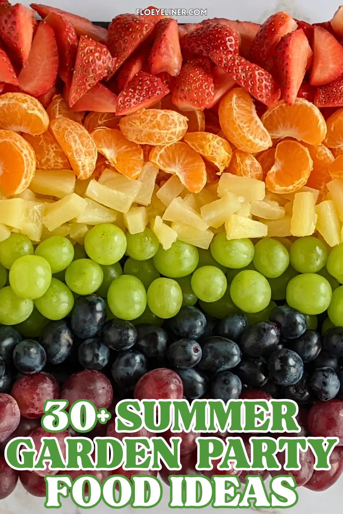 Rainbow Fruit Tray - colorful fruit platter in rainbow colors made with fruits and berries like strawberries, mandarin segments, canned pineapple pieces, green grapes, blue grapes, and dark red grapes.