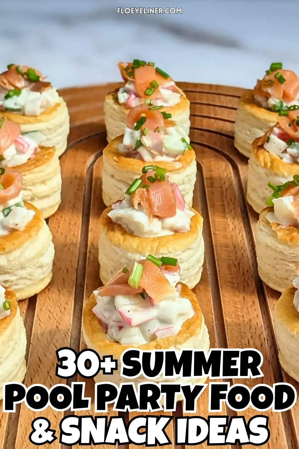 Surimi vol au vent appetizers - puff pastry vol au vent shells filled with a surimi, cucumber, and mayonnaise salad topped with smoked salmon and fresh chives.