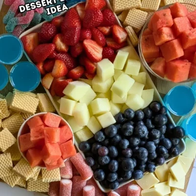 Red, White and Blue Dessert Charcuterie Board - festive red, white, and blue themed dessert tray made with fresh red strawberries and watermelon, plus red sour gummy candies; white honeydew melon, vanilla waffles, and white chocolate; and blue blueberries, blue sour gummy candies, and homemade alcohol-free blue Gatorade jello shots.